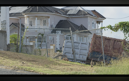 Post-Hurricane Melissa devastation showing a large damaged house with white walls and balcony, red container crashed through fence amid debris – cinematic professional nonprofit video shot highlighting relief needs in Jamaica" These options prioritize "professional nonprofit video" early or integrated for exact-match searches, ensuring descriptiveness for screen readers and better image indexing