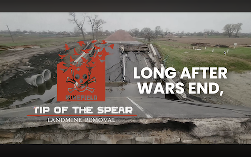War-damaged road in Ukraine labeled 'MINEFIELD' amid fields, overlaid with 'LONG AFTER WARS END' text and logo – evocative nonprofit humanitarian video production footage highlighting enduring explosive threats