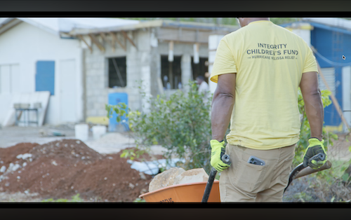 Volunteer in Integrity Children's Fund shirt working on hurricane relief site – nonprofit video campaigns example of community recovery